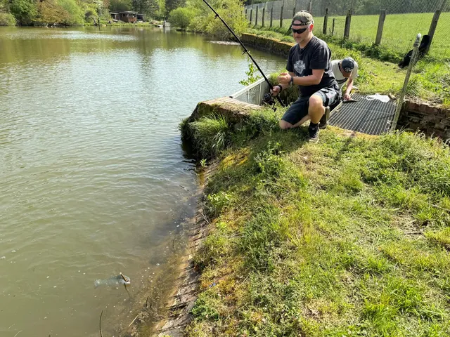 Angler beim Ansitz am grünen Ufer des Bahneweihers